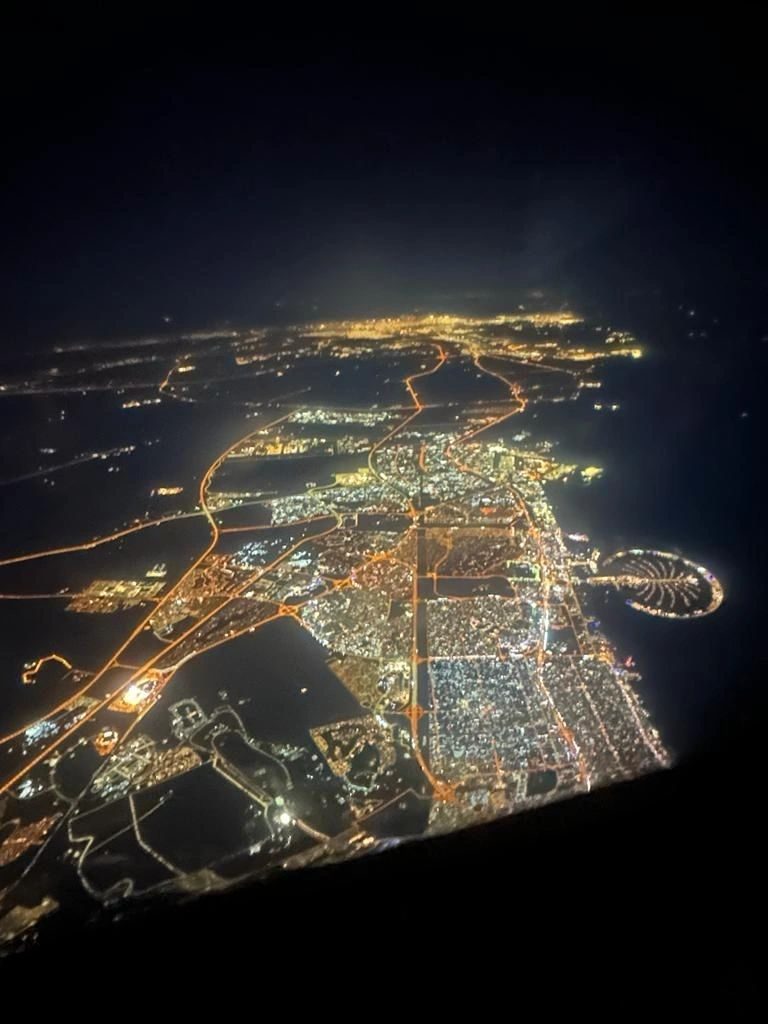 A coastal city lit up at night, seen from the air
